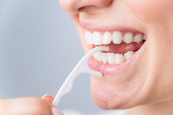 Dùng chỉ nha khoa làm sạch các mảng bám ở kẽ răng